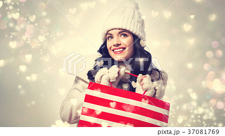 Happy young woman holding a shopping bag Happy young woman holding a shopping bag 37081769