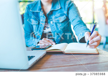 Woman hand writing on notepad with a pen. Woman hand writing on notepad with a pen. 37085988