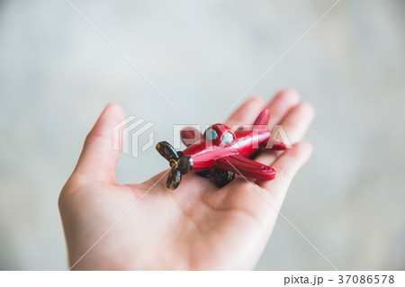 hand holding red toy plane 37086578