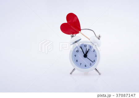 White color alarm clock and red heart shape White color alarm clock and red heart shape 37087147