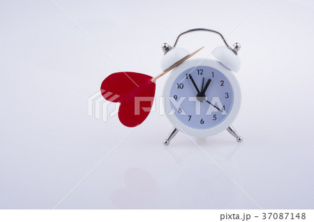 White color alarm clock and red heart shape White color alarm clock and red heart shape 37087148