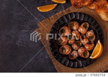 Fried snails with lemon, baguette and parsley. 37093754
