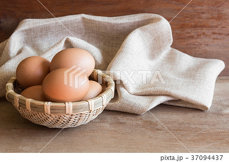 raw chicken egg in bamboo basket on wooden table 37094437