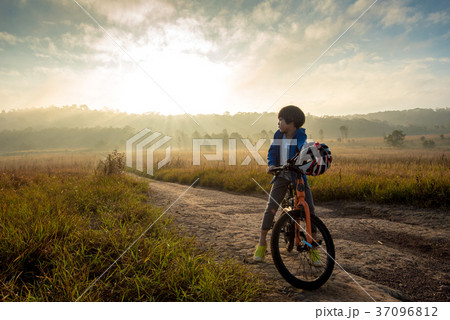 Boy rides a bicycle in the sunrise light 37096812