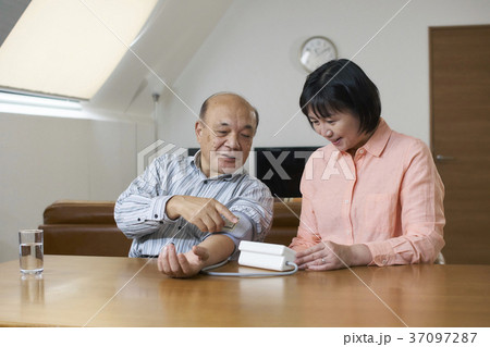 リビングで血圧を測るシニア夫婦 リビングで血圧を測るシニア夫婦 37097287