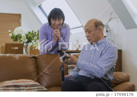 趣味のカメラを持って笑顔で話すシニア夫婦 37098176