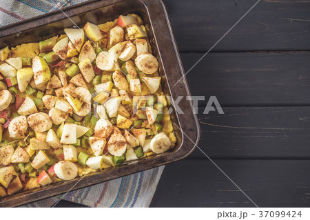 Baking pan with raw dough and cut fruits filling 37099424