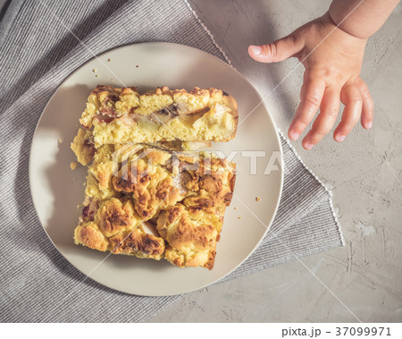 Kid is trying to pick up a piece of pie 37099971