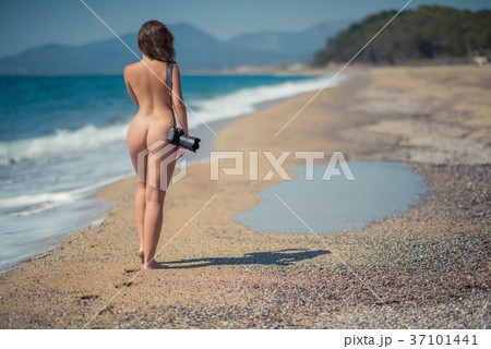 Naked woman in the bikini with camera on the sand - Stock Photo [37101441]  - PIXTA