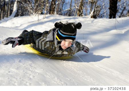 Little boy riding with hills on sleds 37102438