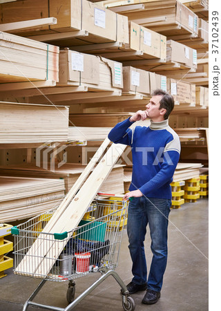 Man chooses boards for construction of store 37102439