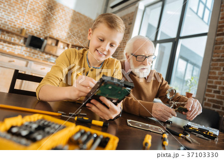 Joyful nice boy concentrating on his activity 37103330