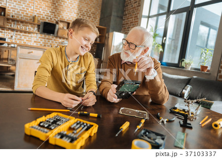 Delighted positive boy talking to his grandfather Delighted positive boy talking to his grandfather 37103337