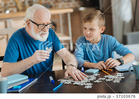Nice elderly man holding a puzzle piece 37103676