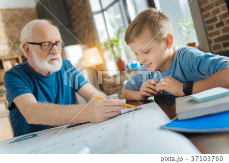 Nice happy boy looking at his grandfathers drawing 37103760