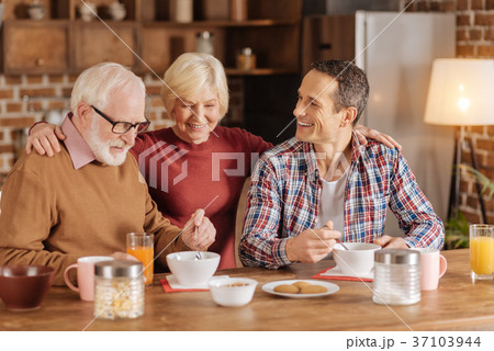 Elderly woman watching husband and son eat oatmeal 37103944