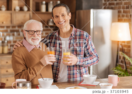 Cheerful father and son posing with glasses of Cheerful father and son posing with glasses of 37103945