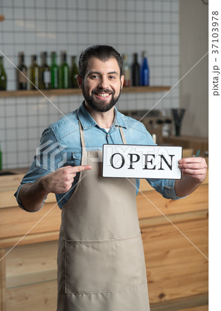 Young smart owner of a cafe showing the opening of Young smart owner of a cafe showing the opening of 37103978