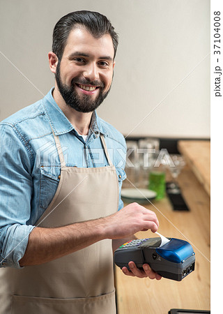 Cheerful professional waiter standing with a 37104008