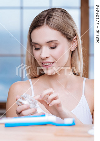 Charming woman taking some cream from jar Charming woman taking some cream from jar 37104343