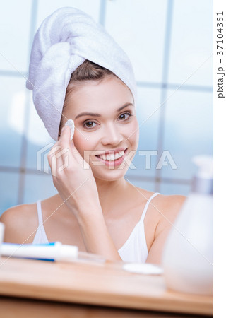 Beautiful woman in towel turban applying tonic Beautiful woman in towel turban applying tonic 37104351