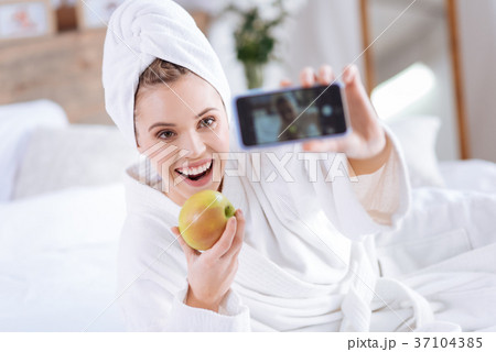 Upbeat woman taking selfie with apple after shower 37104385