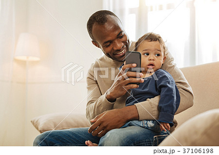 Smiling father playing with his son 37106198