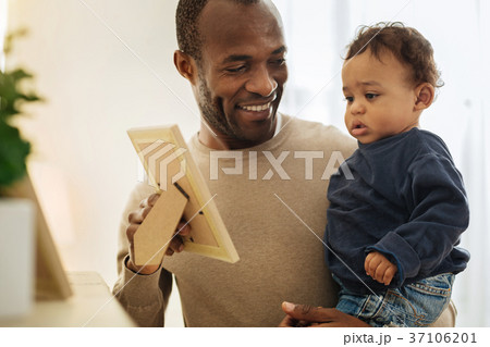 Cheerful daddy showing photos to his son Cheerful daddy showing photos to his son 37106201