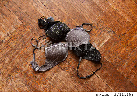 woman bra thrown on wooden floor 37111168