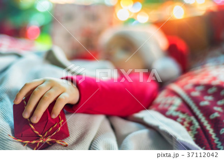 Cute little baby girl sleeping near Christmas tree 37112042