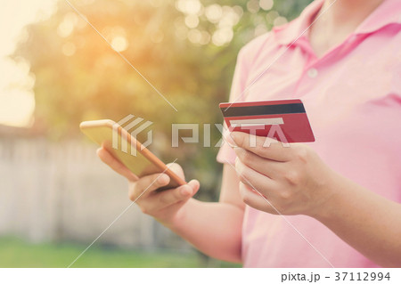 woman hands holding credit card and using cell 37112994
