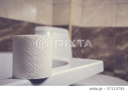a roll of toilet paper on the background of toilet 37113781