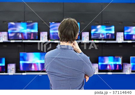 Man looks at LCD TVs in store 37114640