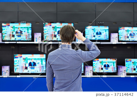 Man looks at LCD TVs in store Man looks at LCD TVs in store 37114642
