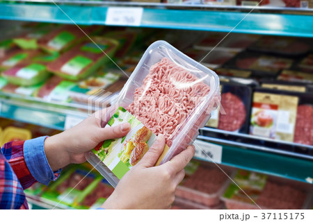 Buyer chooses minced meat in store 37115175