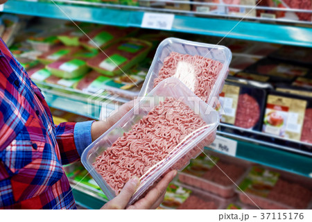 Buyer chooses minced meat in store 37115176