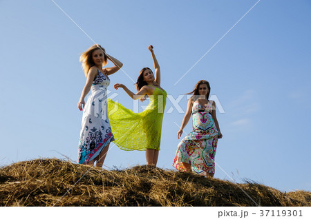 Young beautiful playful women on hay stacks Young beautiful playful women on hay stacks 37119301