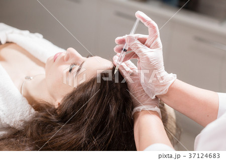 Handsome woman receives an injection in the head 37124683