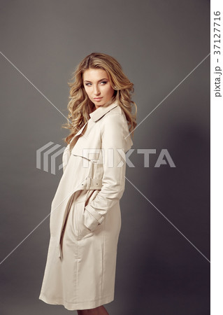 Attractive young woman in beige coat looking at Attractive young woman in beige coat looking at 37127716