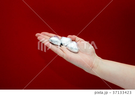 Chocolate heart shaped sweets in the foil laying Chocolate heart shaped sweets in the foil laying 37133423