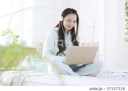 ベッドの上で音楽を聴く女の子 ベッドの上で音楽を聴く女の子 37137518