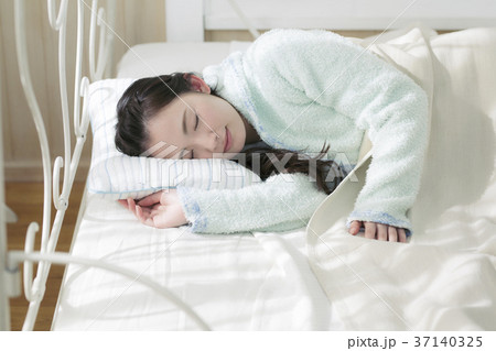 ベッドで寝る代女の子の写真素材