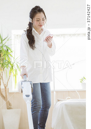 音楽を聴きながら掃除をする女の子 音楽を聴きながら掃除をする女の子 37142427