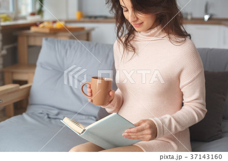 Young pregnant woman on the sofa at home in winter Young pregnant woman on the sofa at home in winter 37143160