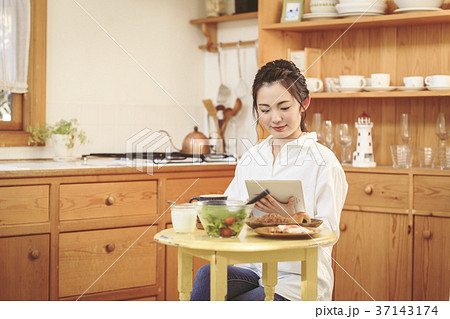 朝ごはんを食べながらニュースを見る女の子 朝ごはんを食べながらニュースを見る女の子 37143174