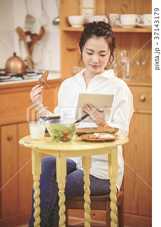 朝ごはんを食べながらニュースを見る女の子 朝ごはんを食べながらニュースを見る女の子 37143179