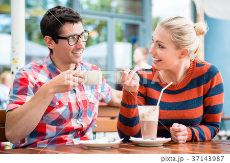 Couple having coffee in a street cafe Couple having coffee in a street cafe 37143987
