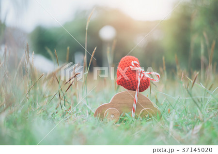 Wooden car toy carrying red heart on top. Wooden car toy carrying red heart on top. 37145020