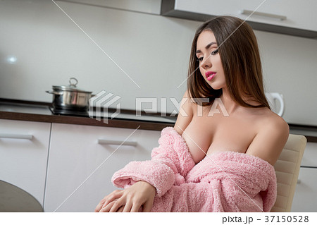Sexy busty girl posing in pink bathrobe on kitchen - Stock Photo 37150528 