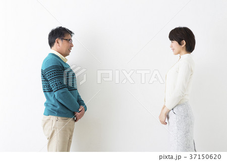 白バックに向かいあって立つ夫婦 37150620